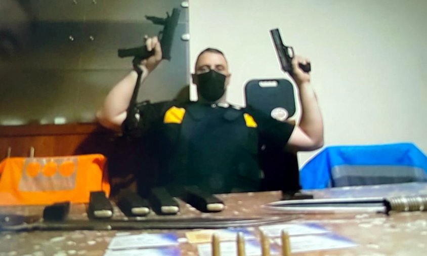Imatge de l'exvigilant de seguretat amb armilla i diverses armes