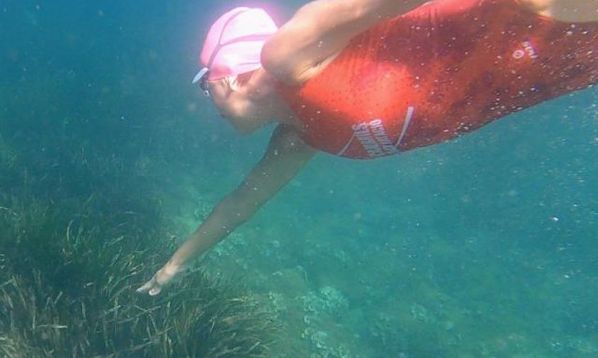 Imatge d'una nedadora del Cambrils Club Natació tocant el fons de posidònia, a la zona del Cavet