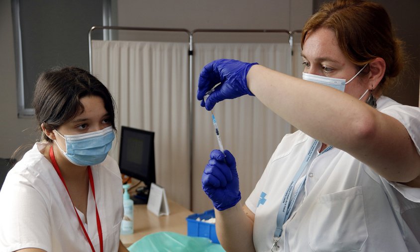 Imatge d'unes infermeres preparant una dosi de la vacuna de record de la covid-19