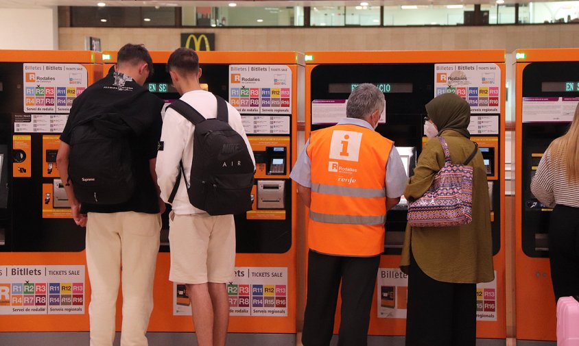 Diverses persones en màquines d'autovenda de l'estació de Sants de Barcelona