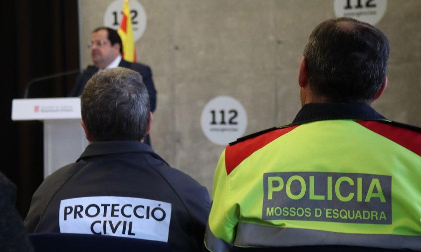 Dos agents de Protecció Civil i dels Mossos durant la roda de premsa del conseller d'Interior, Joan Ignasi Elena, el passat dimecres