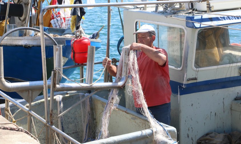 Un pescador feinejant al port de Roses