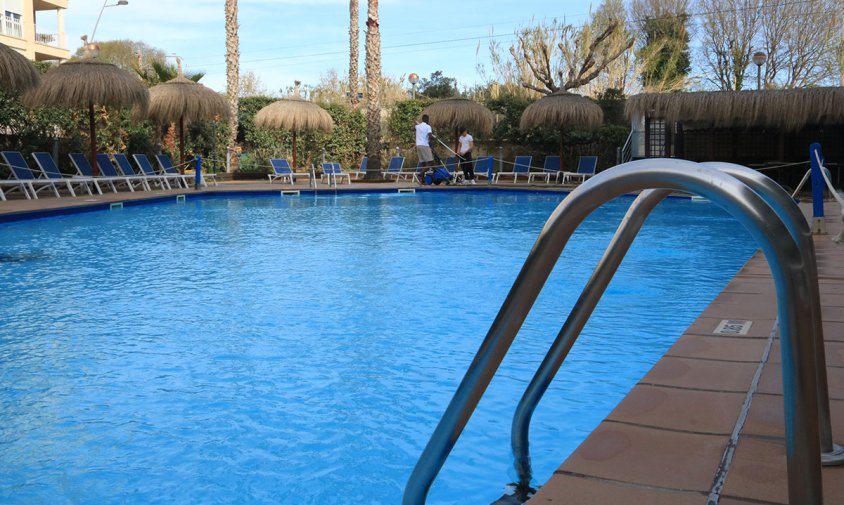 Dos operaris preparen la piscina de l'Hotel Sol Cambrils just abans de l'inici de Setmana Santa.