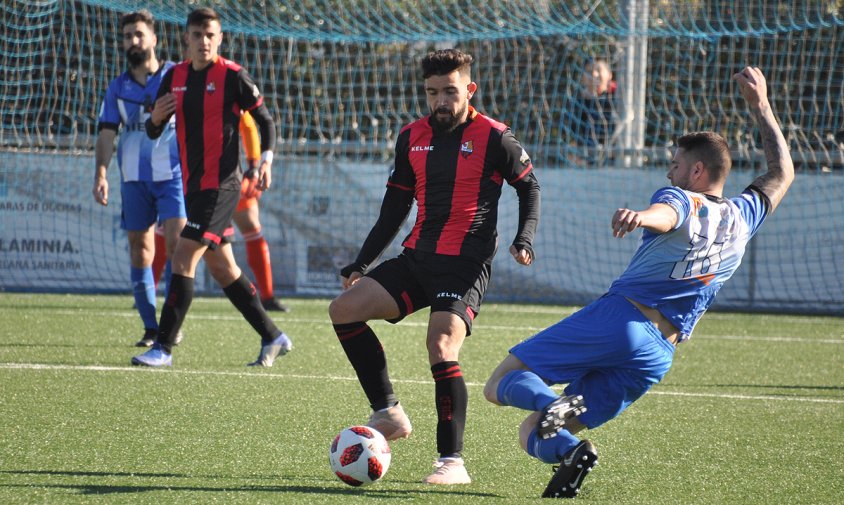 Adrià Arjona controla la pilota davant d'un jugador del Santfeliuenc en el partit disputat aquest passat dissabte al matí