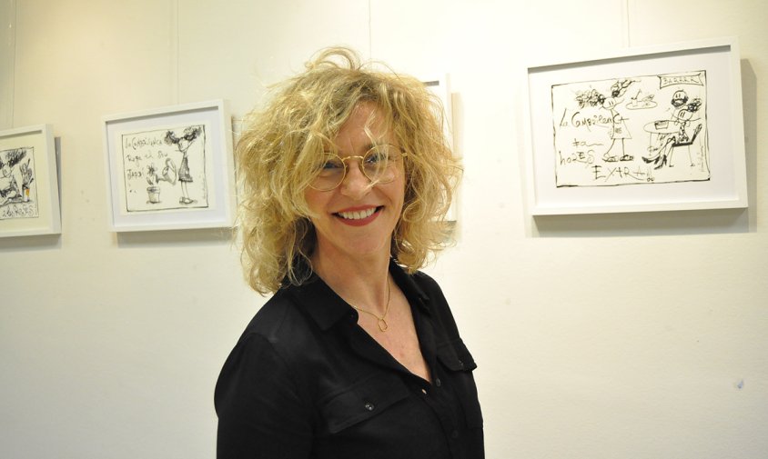 Nuri Mariné al costat d'algunes de les il·lustracions que formen part de la mostra