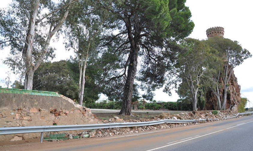 El tram de mur caigut es troba al costat de la torre del Mirador, tocant a la carretera de Montbrió