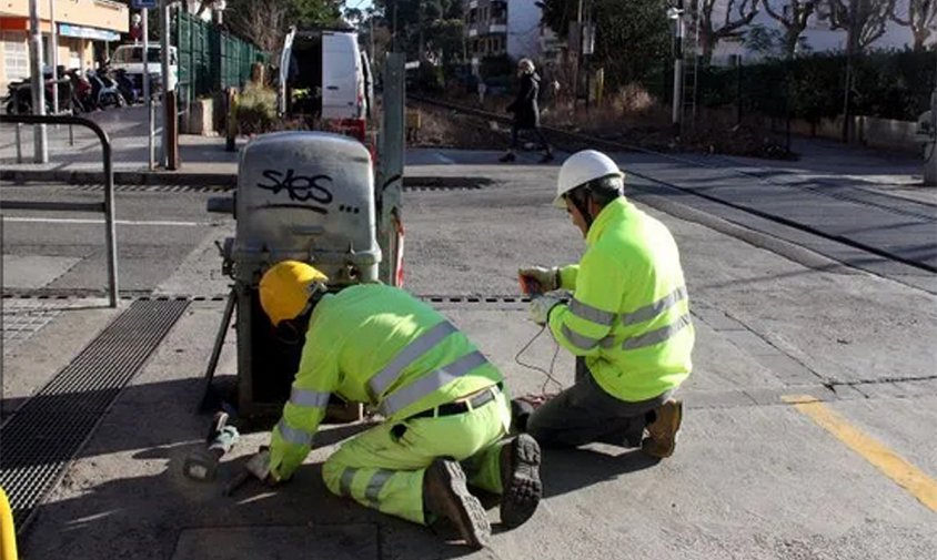 Tècnics d'Adif realitzant treballs de desmuntatge del pas a nivell que travessa pel carrer de Barcelona de Salou