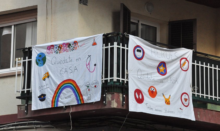 Pancartes elaborades per la canalla penjades a un balcó del barri de l'Eixample