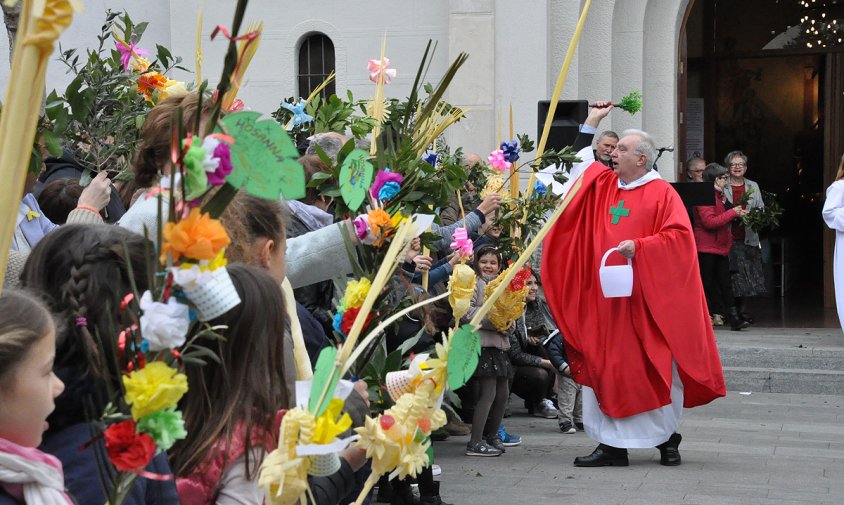 Mossèn Joan M. Banús, rector de la parròquia de Sant Pere, beneint les palmes i rams ahir al migdia