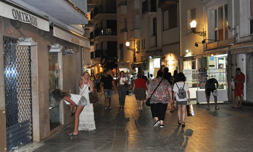 Gent passejant pel carrer del Consolat de Mar a l'hora del tancament dels comerços, ahir a la nit