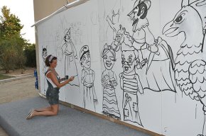 L'artista Nuri Mariné dibuixa el seguici popular en el mural que avui han d'acolorir els nens