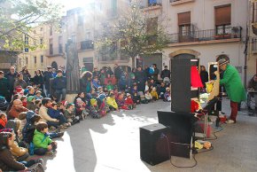La canalla gaudeix del conte del Patufet a la plaça de l'església de Santa Maria