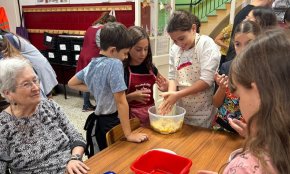 Avis i alumnes de sisè cuinen uns panellets intergeneracionals