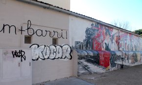 Pinten un grafiti al costat del mural de les festes del barri de l'Eixample