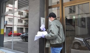 Un grup de voluntaris reparteix les targetes moneder per als alumnes amb beques menjador