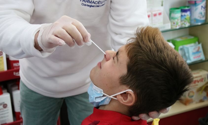 Imatge d'un farmacèutic fent-li un test a un xiquet