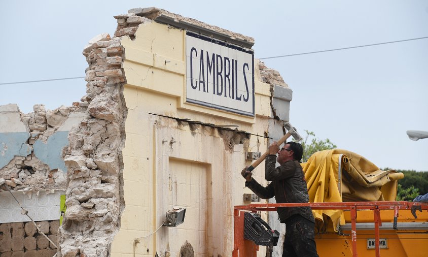 Un operari, ahir a la tarda, treballant en el mur on hi ha el cartell de ceràmica