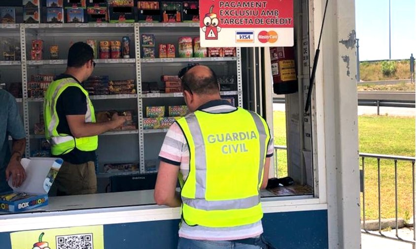 Dos agents inspeccionant una caseta de venda de petards