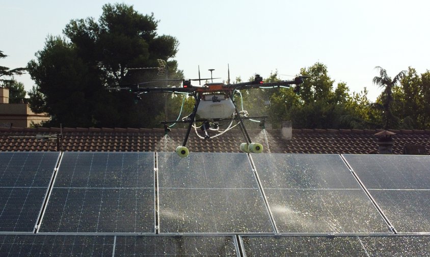 Un dron fent tasques de neteja de plaques solars en una teulada d'uns casa