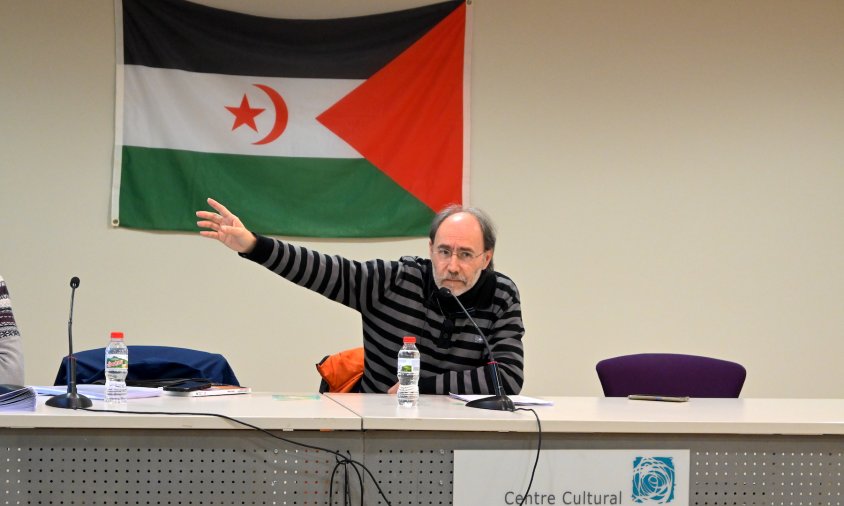 Tomàs Callau, autor del llibre «El Sàhara Occidental. El segrest d'un poble», i al fons una bandera saharaui