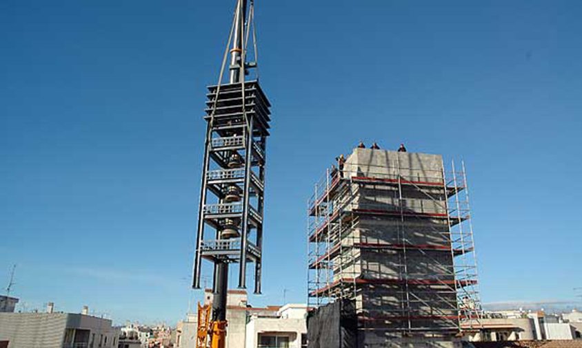 Amb l'ajuda d'una grua de grans dimensions, el coronament amb les campanes va ser col·locat al capdamunt de l'estructura del campanar