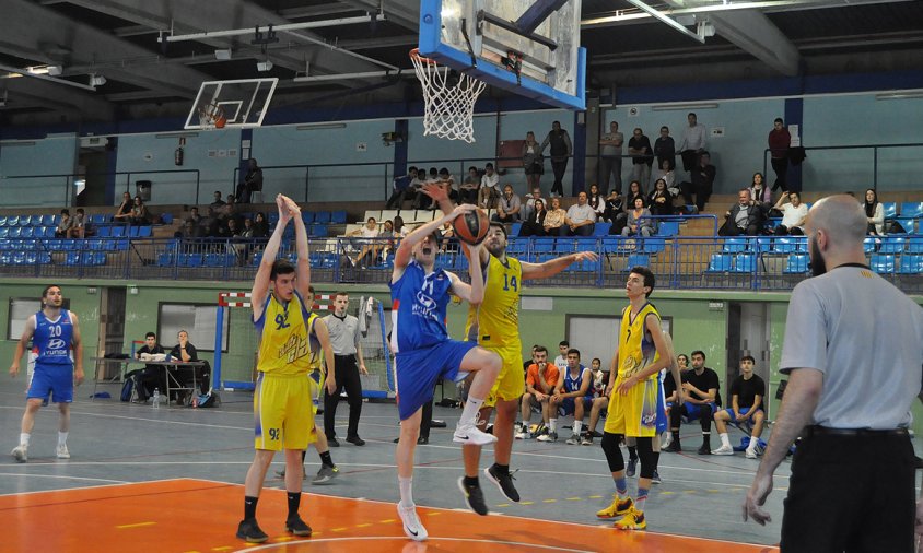 Guillem Álvarez del CB Cambrils entrant a cistella davant l'oposició d'un jugador de l'AE Claret