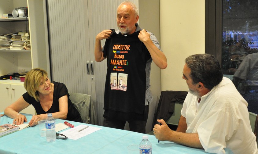 Gustavo Hernández Becerra mostra la samarreta que es col·loca abans de signar llibres, al costat de Carmen Serra i Ramón García Mateos