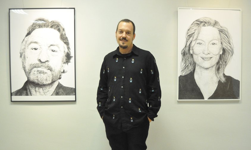 Eloy Guerra al costat d'alguns dels seus quadres de l'exposició instal·lada a la Sala Àmbits