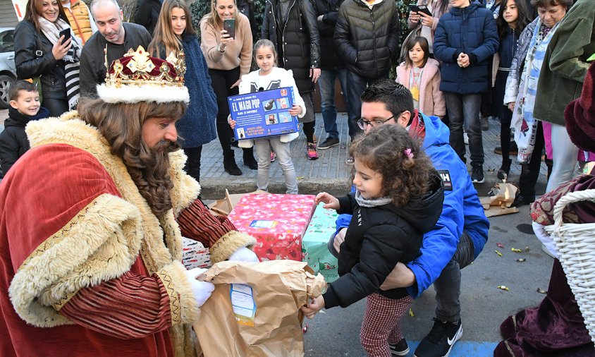 El Rei Gaspar fa l'entrega d'un regal a una xiqueta, ahir al matí