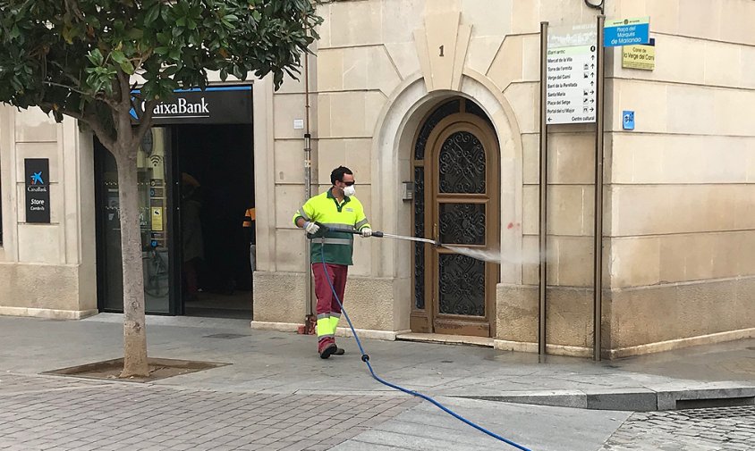 Un operari de Secomsa fent la desinfecció prop d'una entitat bancària, aquest matí