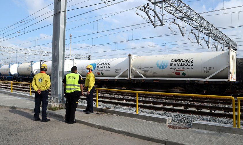 Efectius del SEM i d'un agent de seguretat d'Adif davant dels vagons del tren aturat a les vies del polígon Francolí de Tarragona a causa una fuita de diòxid de carboni