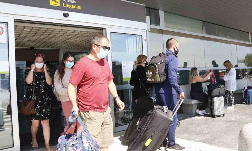 Turistes amb maletes, a la terminal d'arribades de l'aeroport de Reus, en el primer avió que aterra a la capital del Baix Camp des de l'alarma
