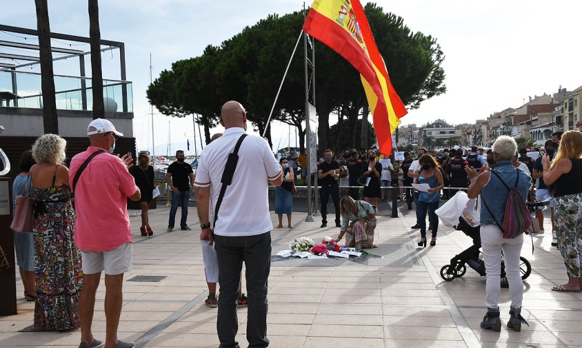 La gent de Vox en el moment de fer l'ofrena floral mentre que al darrera hi havia la concentració antifeixista