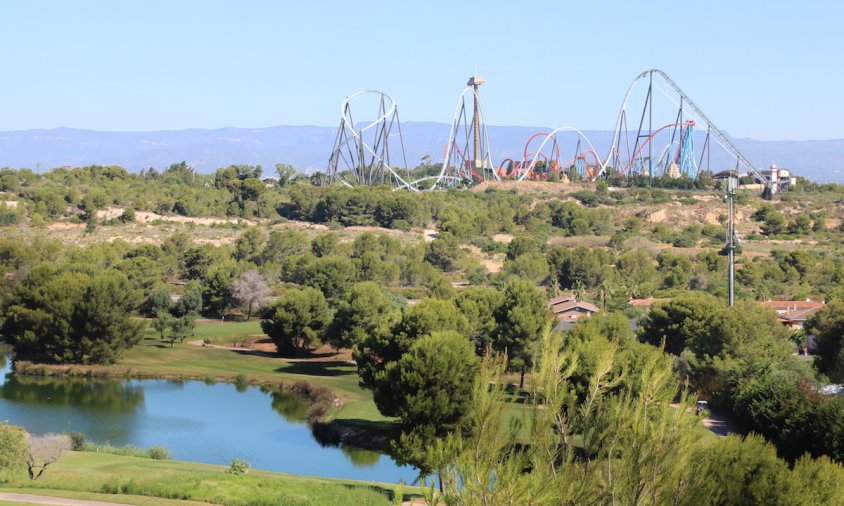 Terrenys del Centre Recreatiu i Turístic (CRT) de Vila-seca i Salou, amb un llac i camp de golf de PortAventura (Lumine) en primer terme, i les atraccions al fons, en una imatge del juliol del 2017