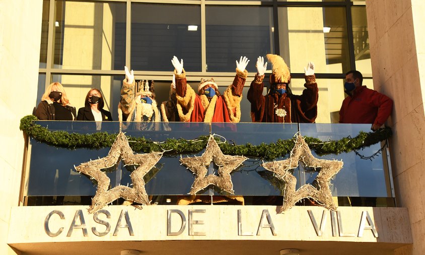 Melcior, Gaspar i Baltasar saludant des del balcó de la Casa de la Vila i amb les mascaretes posades en la festa de Reis de l'any passat