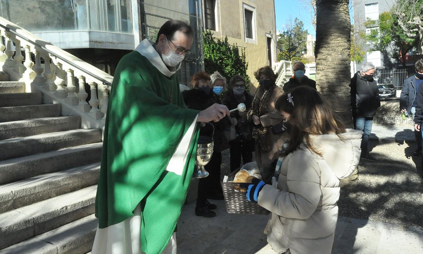 Mossèn Joan M. Padrell beneint el conillet d'Índies d'una xiqueta, ahir al migdia al pati de l'Ermita