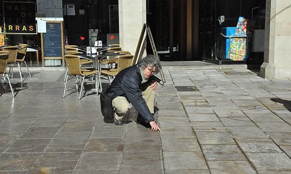 El president de l'Associació de Veïns del Barri Antic, Joan Carles Massagué, mostra el límit del paviment que ha estat tractat aquesta nit, a la dreta, i el que encara no ho està, a l'esquerra, a la plaça d'Espanya