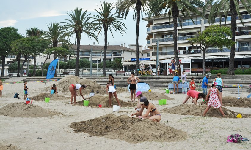 Diverses famílies fent les seves creacions al taller d'escultures de sorra d'ahir a la tarda