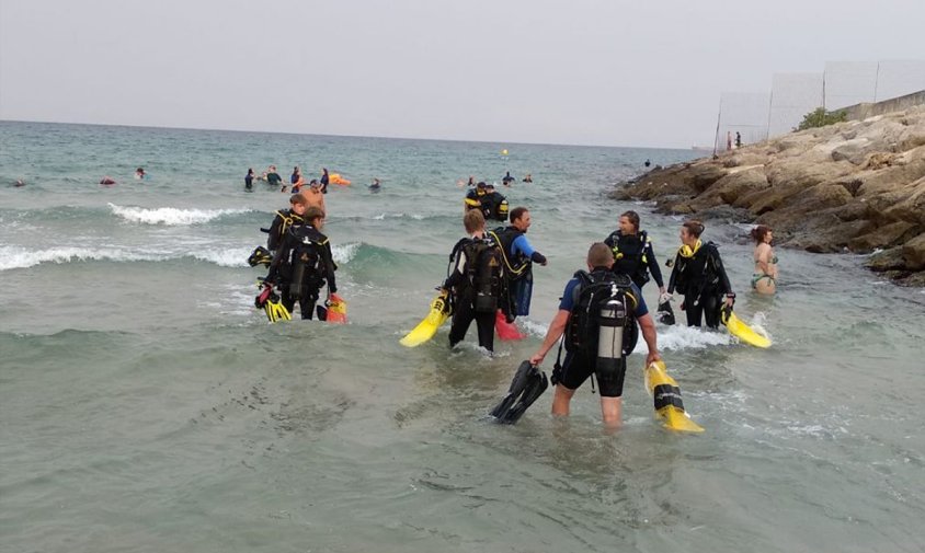 Els bussejadors entrant al mar per recollir-ne residus, ahir a la platja del Miracle de Tarragona