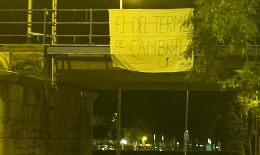 Pancarta situada al pont de l'antiga via del tren en el vial de baixada