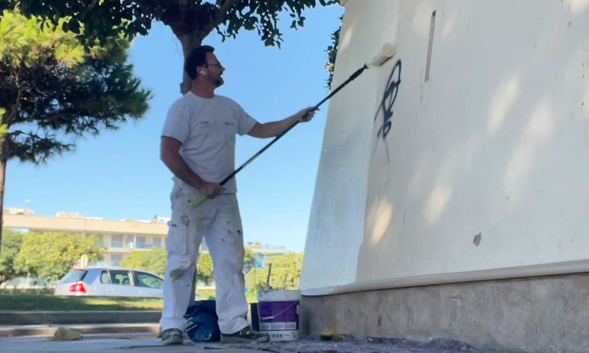 Un pintor repintant les parets de l'edifici de la Torre de l'Esquirol