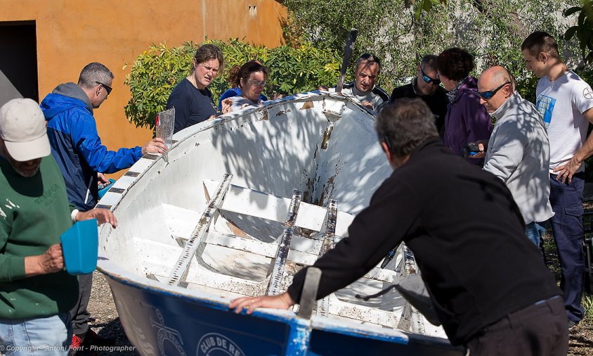 Membres del club Rem Cambrils reparant el llagut que els ha deixat l'Ajuntament de l'Ametlla de Mar