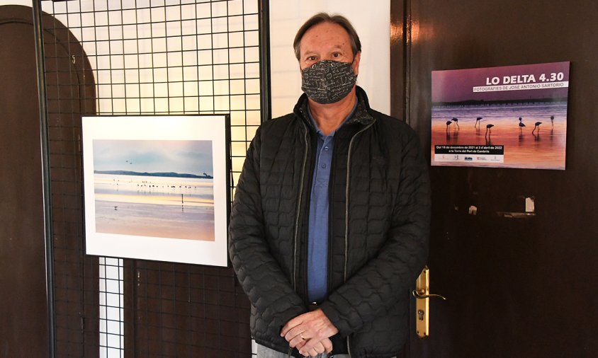 José Antonio Sartorio al costat del cartell de l'exposició i una de les seves fotografies